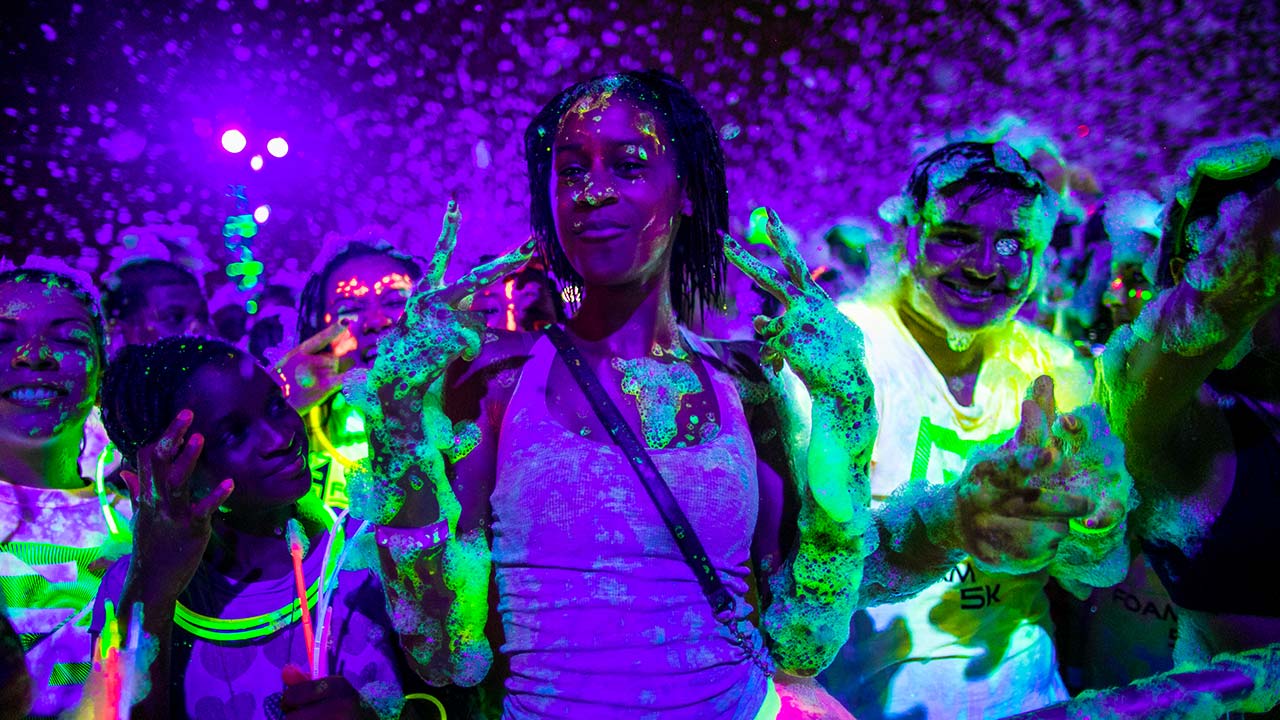 UV foam crowd throwing peace signs